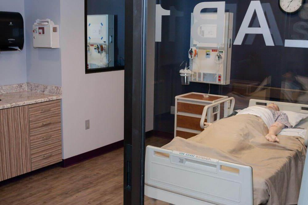 透过模拟病房的窗户看到躺在病床上的人体模型