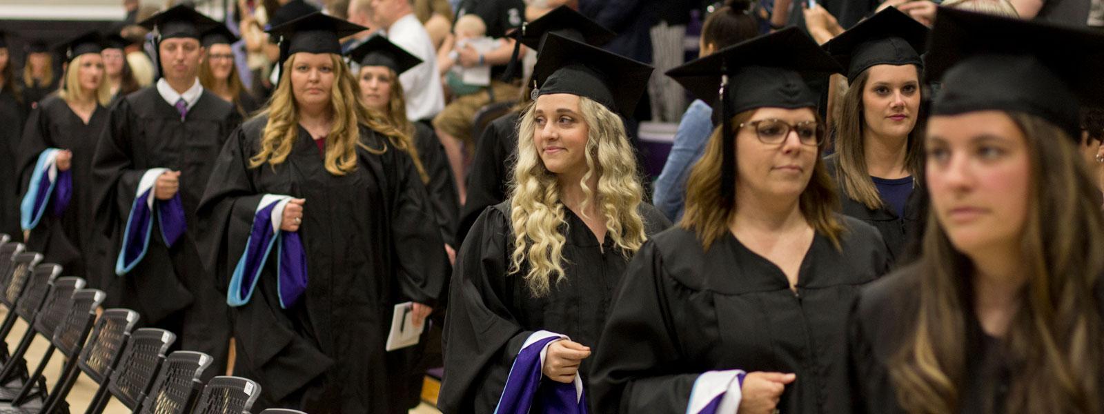 毕业典礼上，毕业生们手持硕士帽走在游行队伍中