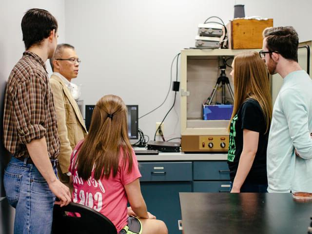 教授向一群学生解释化学实验设备